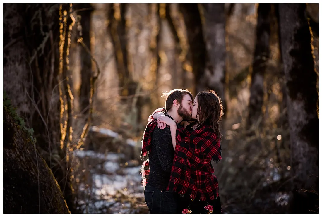 Engagment photo session of a couple taken in trees and snow at Dorris Ranch in Oregon