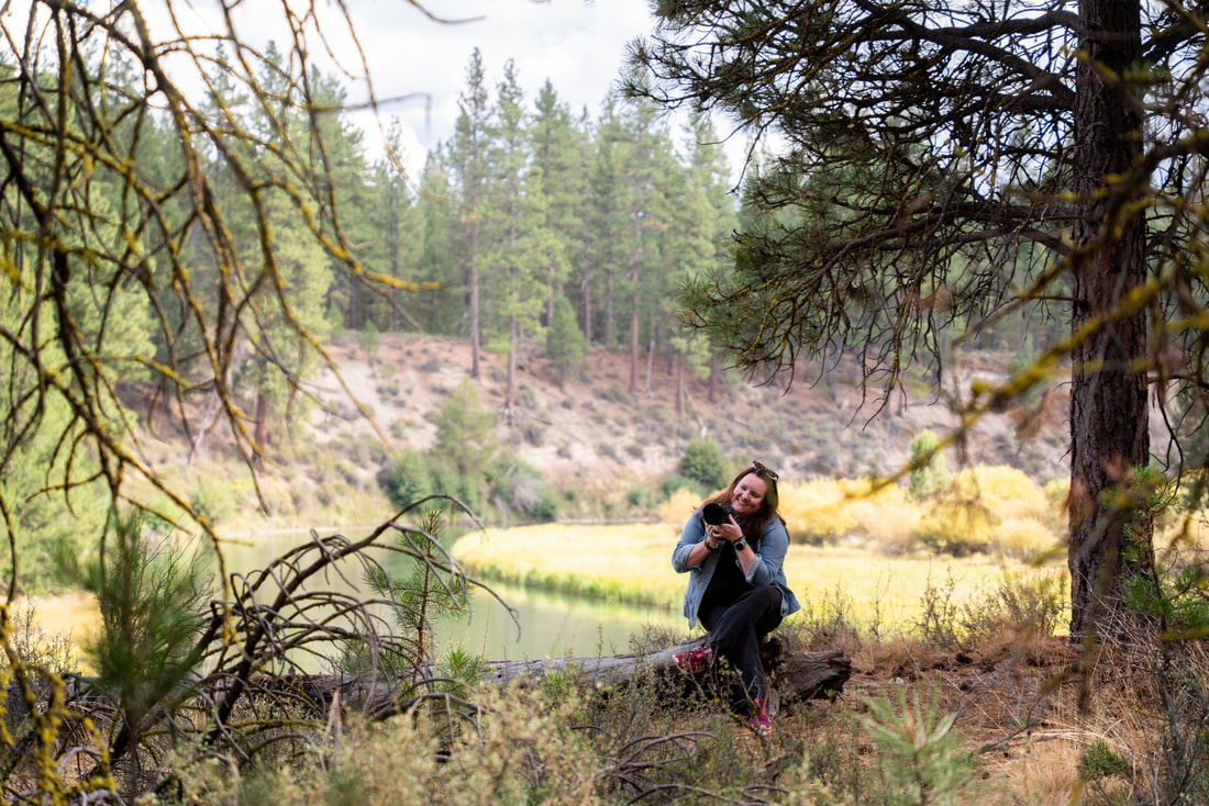 Lynn Marie with her camera beside a river in Central Oregon