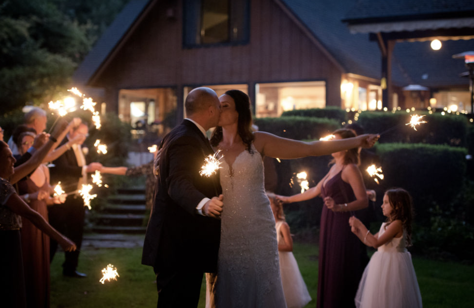 Sparkler exit photo of wedding couple at Eagle Rock Lodge in Oregon on the McKenzie River.  Photography by Lynn Marie